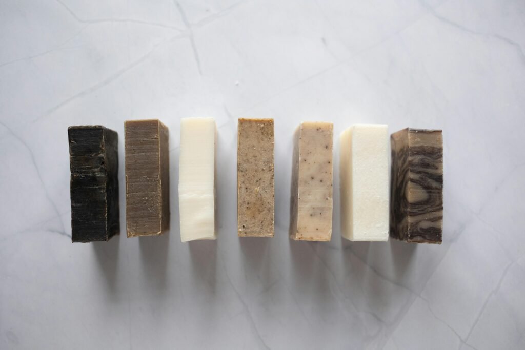 Collection of handcrafted natural soaps on a marble surface, showcasing earthy tones and textures.